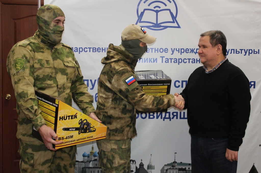 Директор библиотеки Хаертдинов И.А. вручает бойцам бензопилы